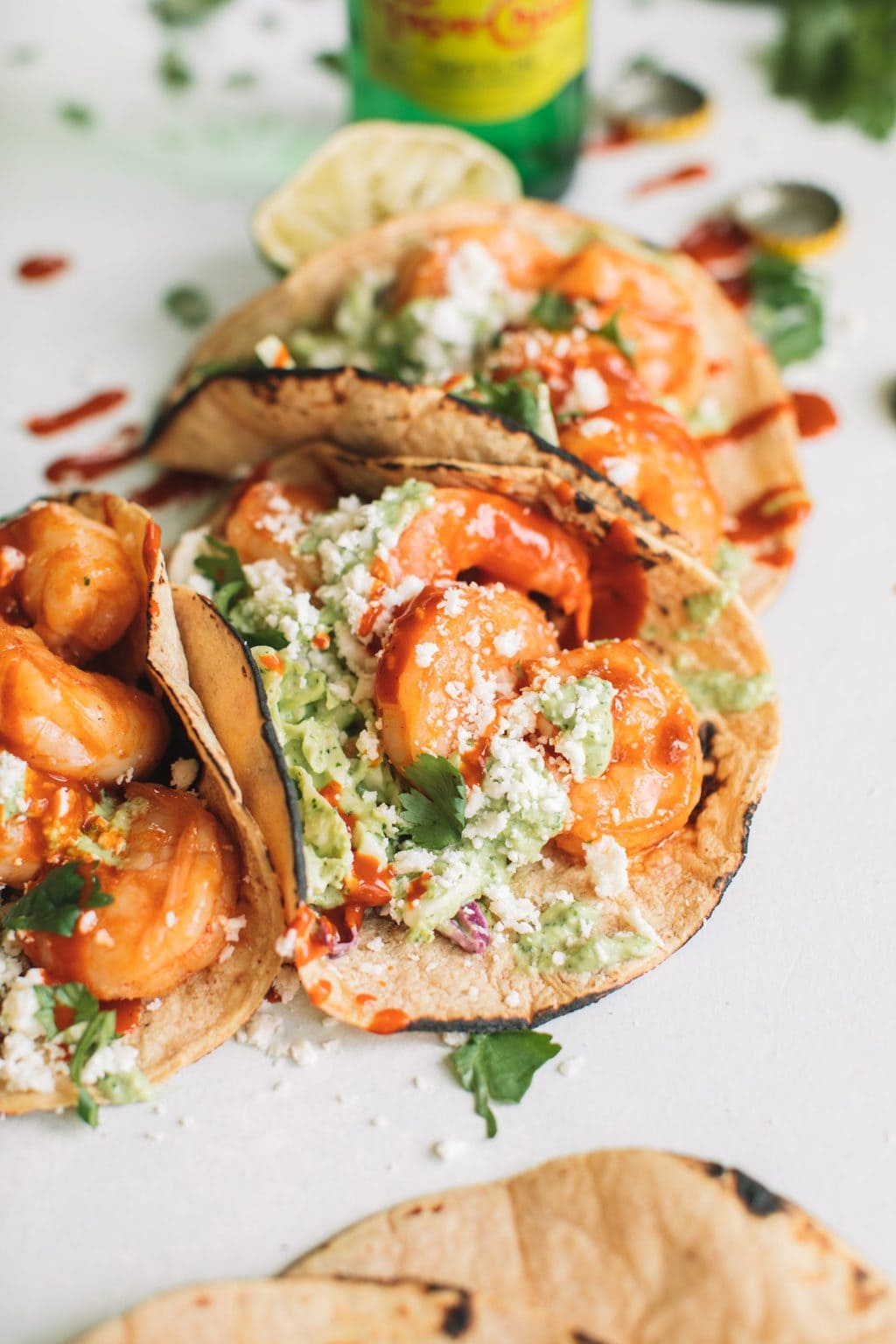 easy shrimp taco recipe with cilantro lime slaw in charred corn tortillas on white surface