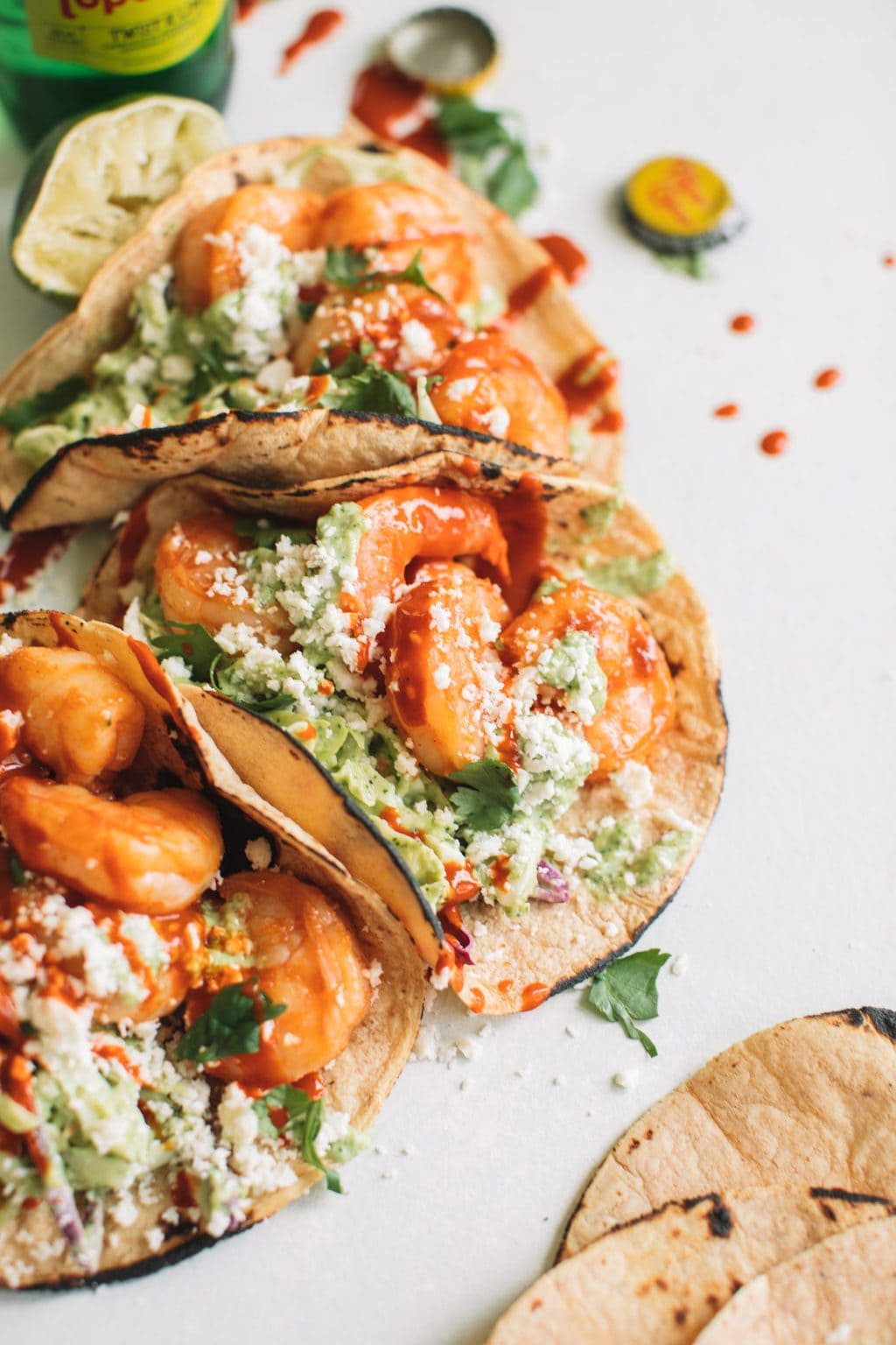 easy shrimp taco recipe with cilantro lime slaw in charred corn tortillas on white surface