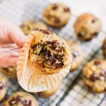 hand holding zucchini chocolate chip muffin with bite taken out