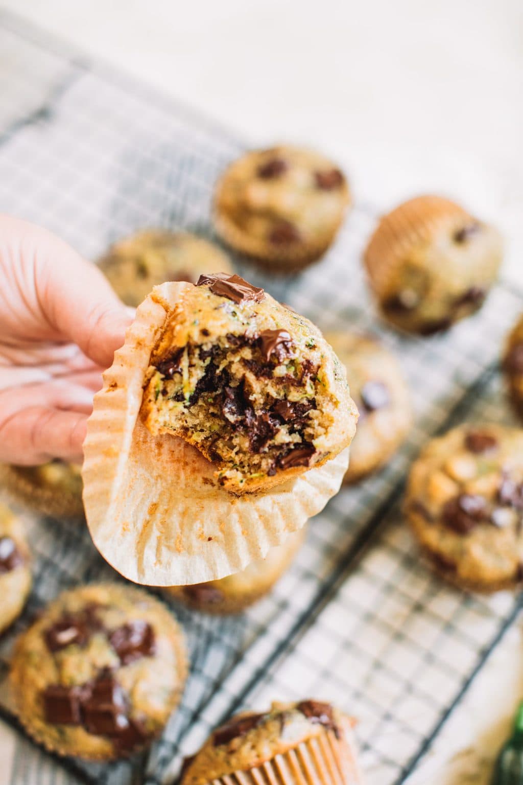 hand holding zucchini chocolate chip muffin with bite taken out