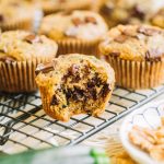 muffin recipe with zucchini and chocolate chips with bite taken out on wire rack