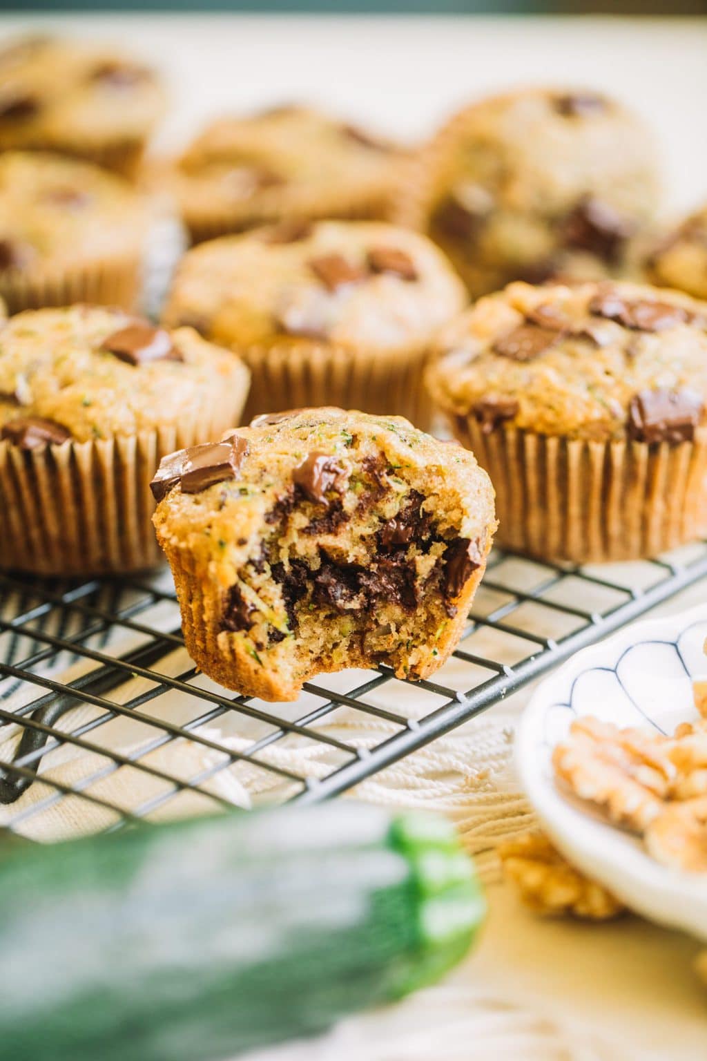 muffin recipe with zucchini and chocolate chips with bite taken out on wire rack