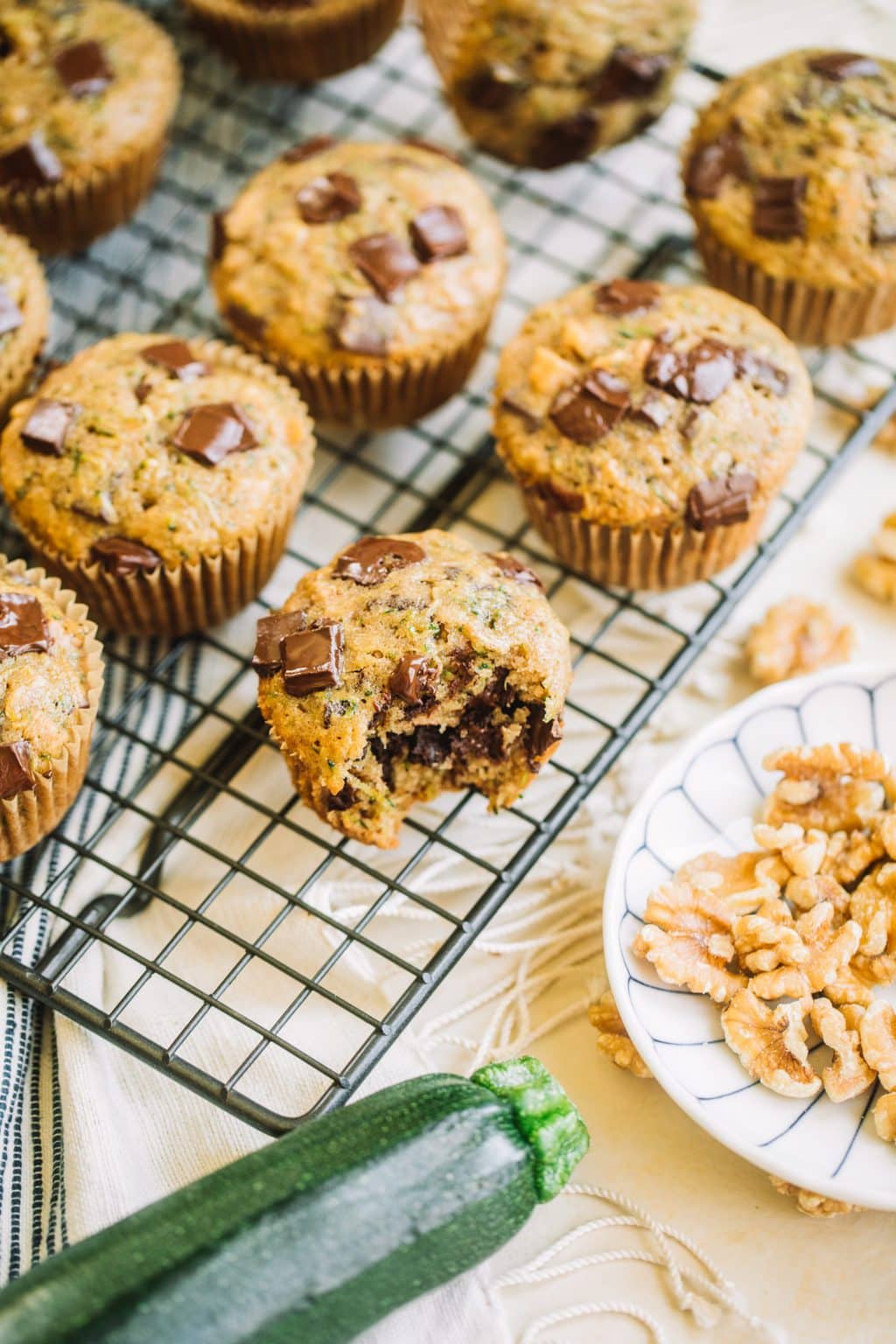 muffin recipe with zucchini and chocolate chips with bite taken out on wire rack