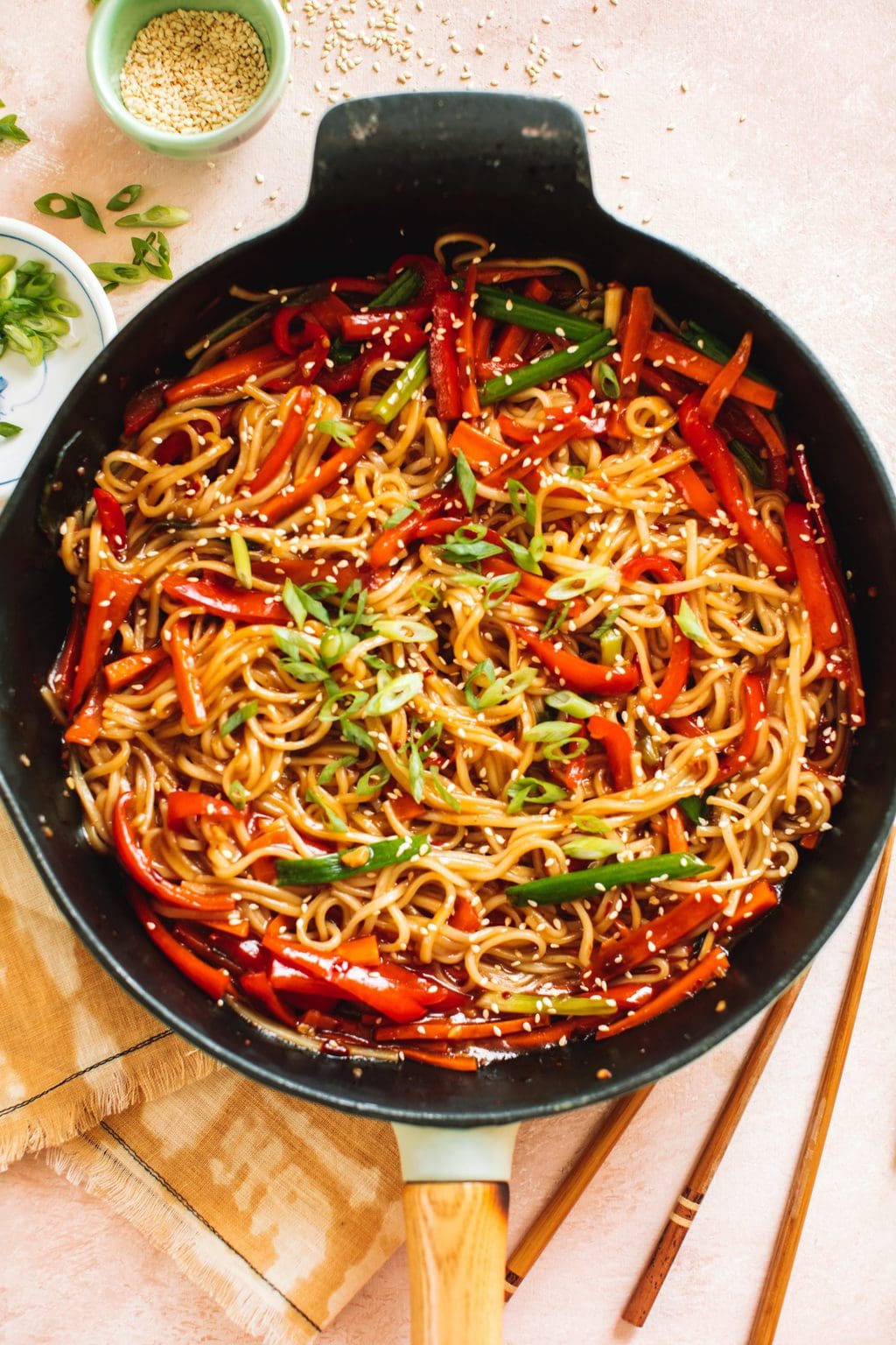 lo mein noodles and vegetables stir fried in cast iron pan with chopsticks