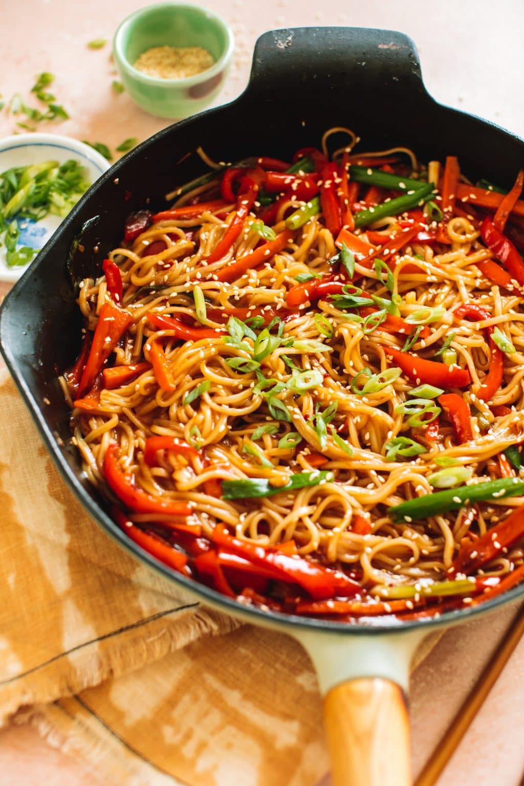 lo mein noodles and vegetables stir fried in cast iron pan with chopsticks