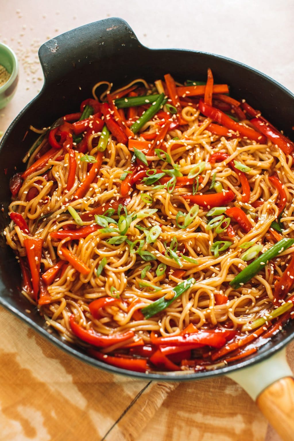 lo mein noodles and vegetables stir fried in cast iron pan with chopsticks