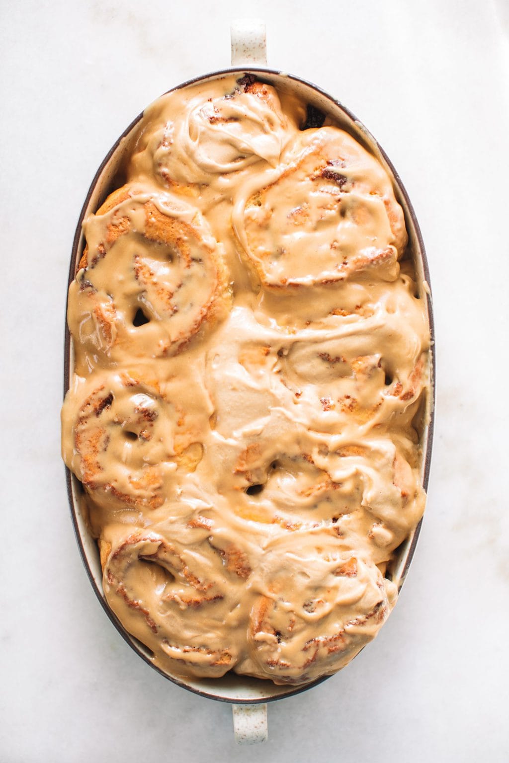 A pan of cinnamon rolls covered in an espresso icing.