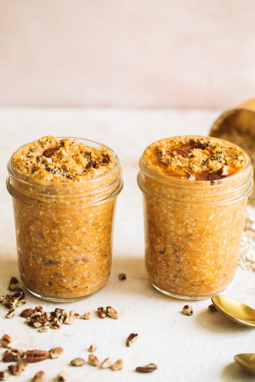 two small jars easy pumpkin pie overnight oats topped with maple syrup and pecans