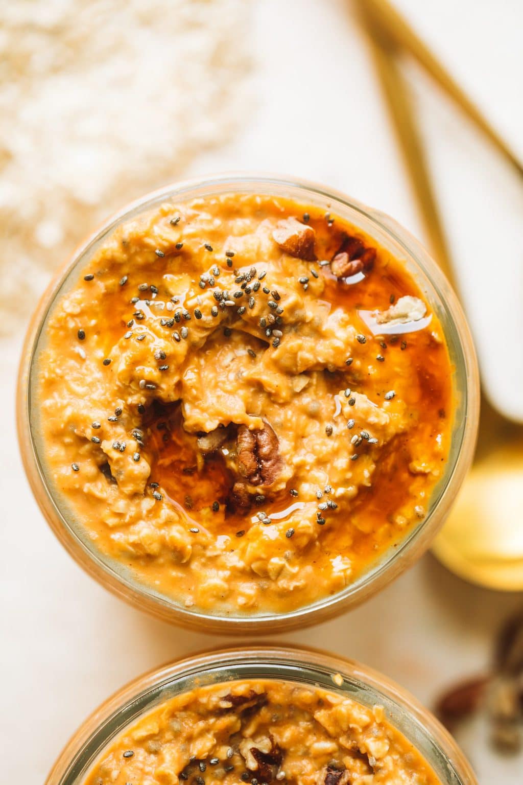 easy pumpkin pie overnight oats in glass jar topped with maple syrup and pecans