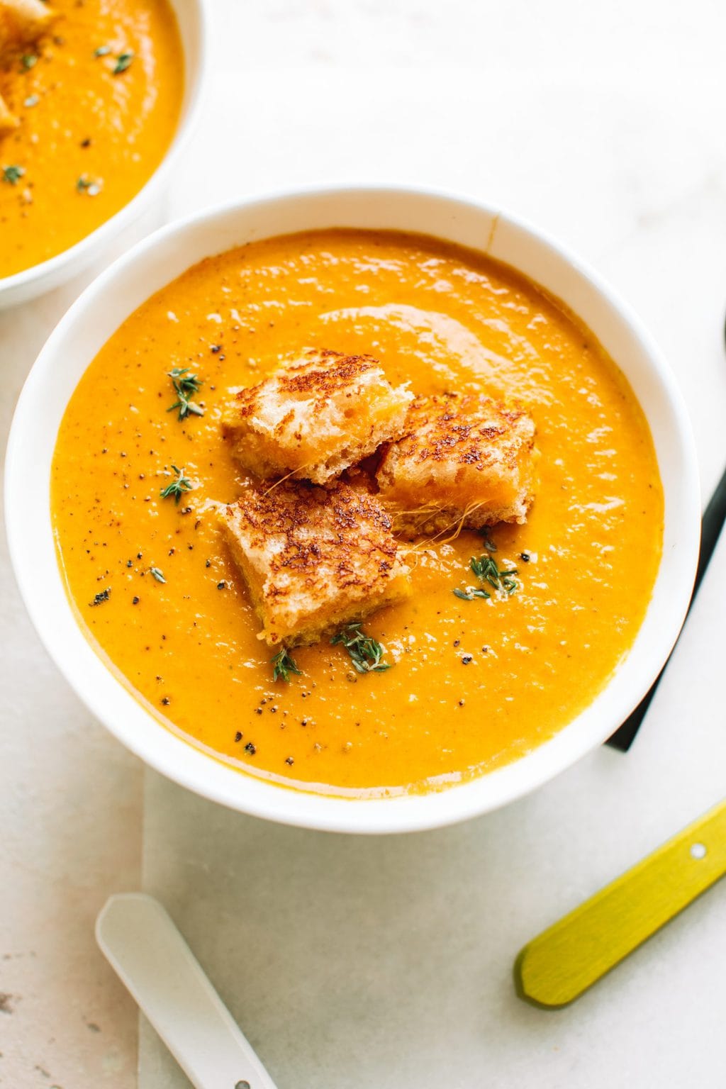 best pumpkin soup recipe in white bowl topped with grilled cheese croutons