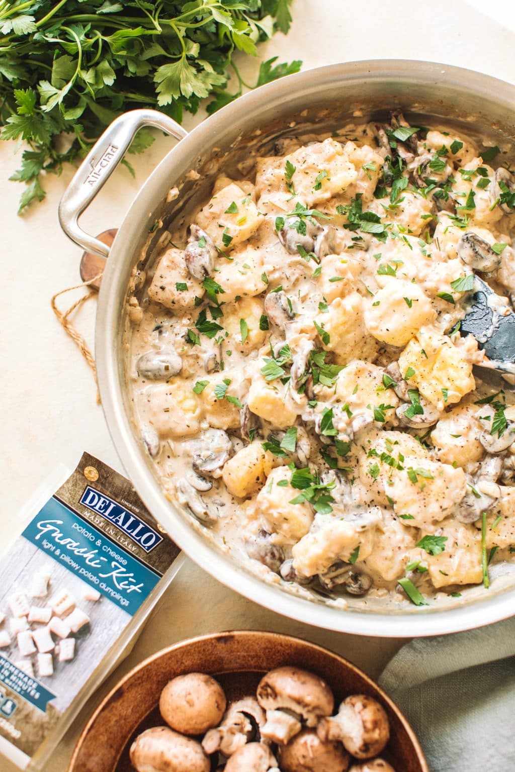 Mushrooms and gnocchi in a cream sauce garnished with parsley in a skillet.