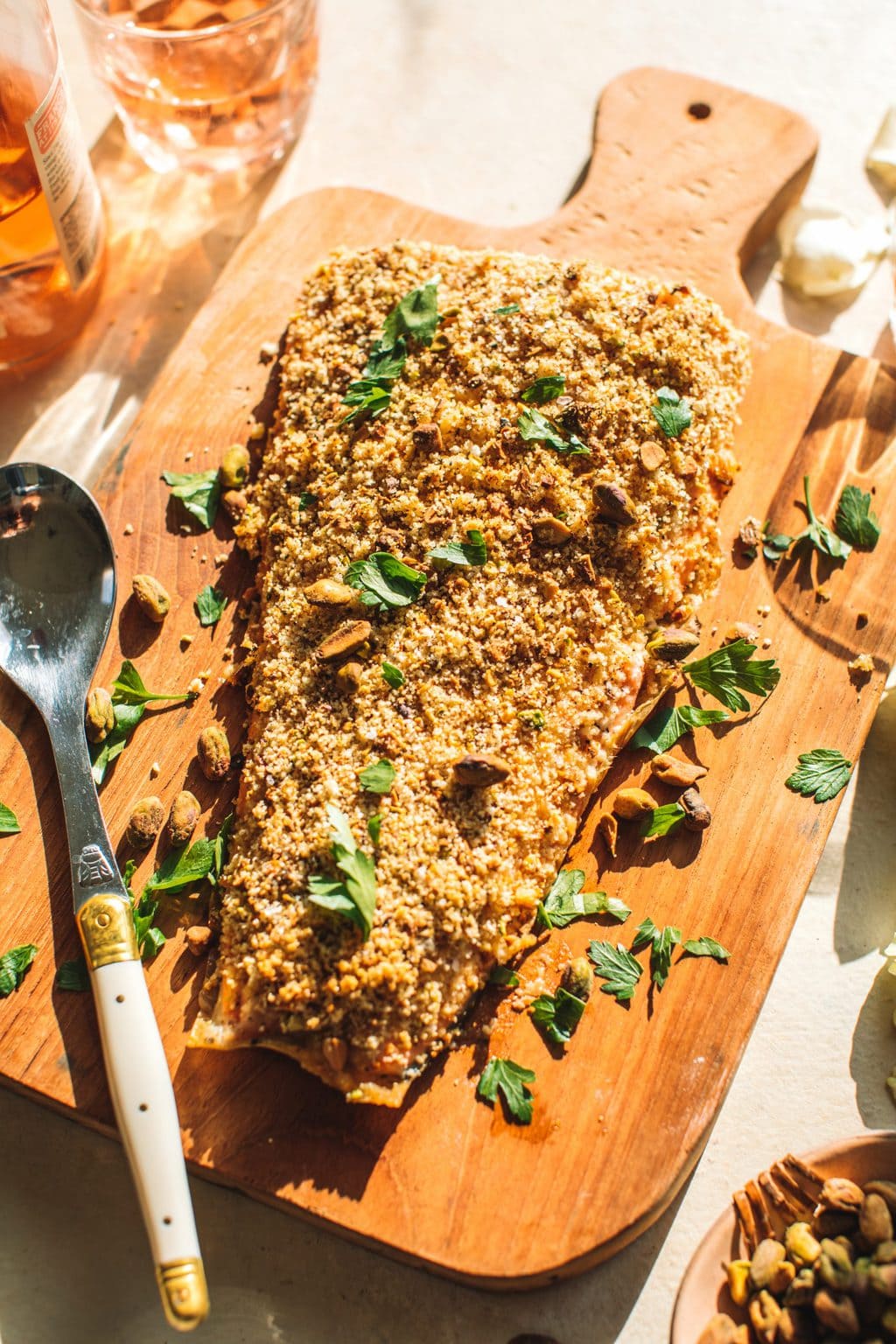 Pistachio crusted salmon served on a wooden board. 