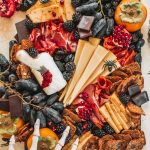 A spooky cheeseboard with cheeses, fruits, crackers and nuts.