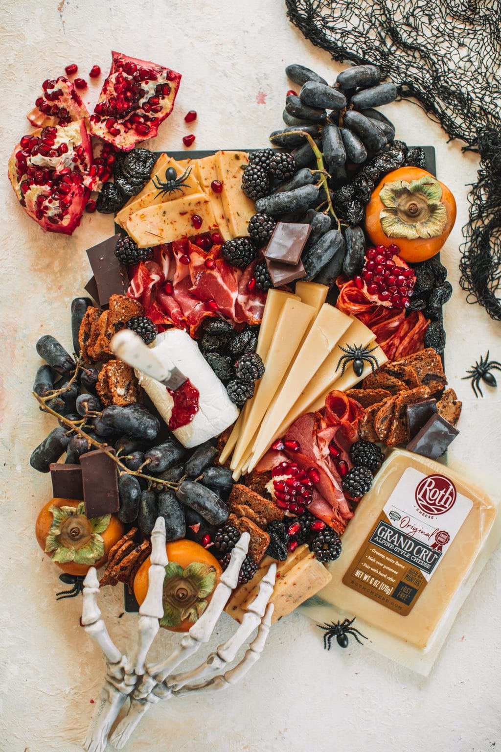 A spooky cheeseboard with cheeses, fruits, crackers and nuts. 