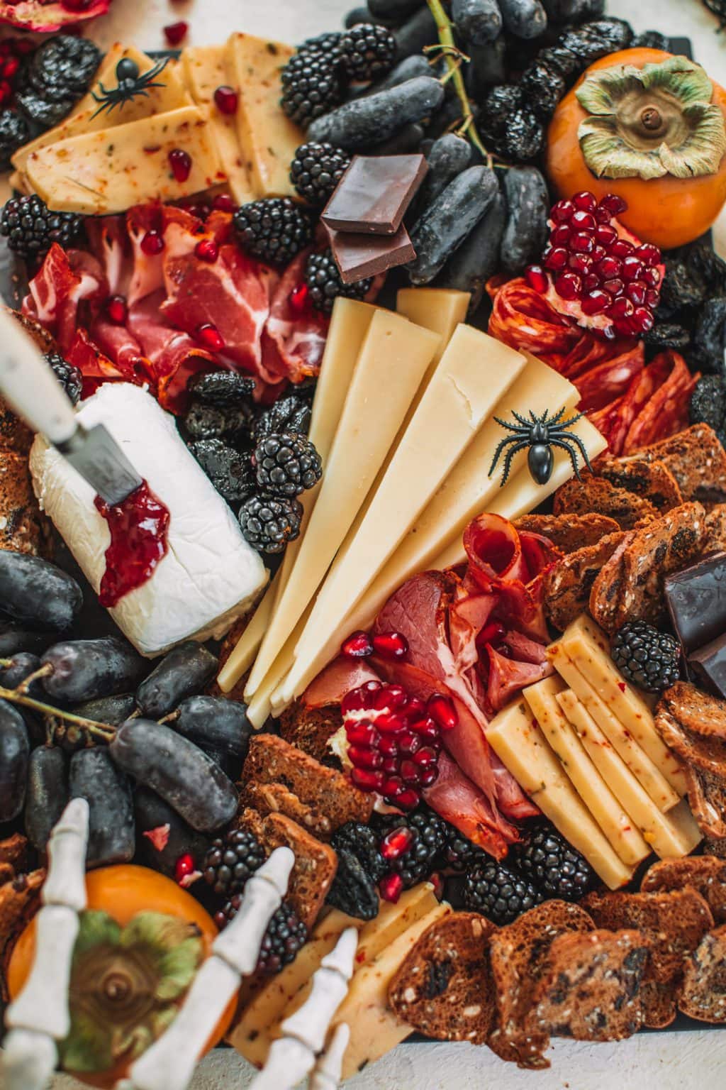 A spooky cheeseboard with cheeses, fruits, crackers and nuts. 