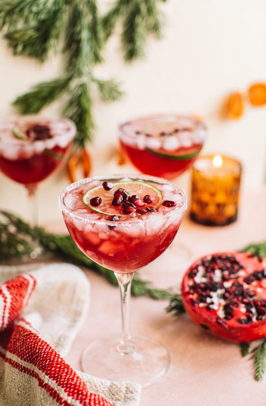 Cocktail glass filled with pomegranate christmas margarita on holiday tablescape