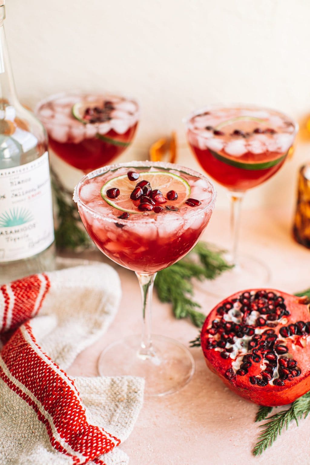 Cocktail glass filled with pomegranate christmas margarita on holiday tablescape