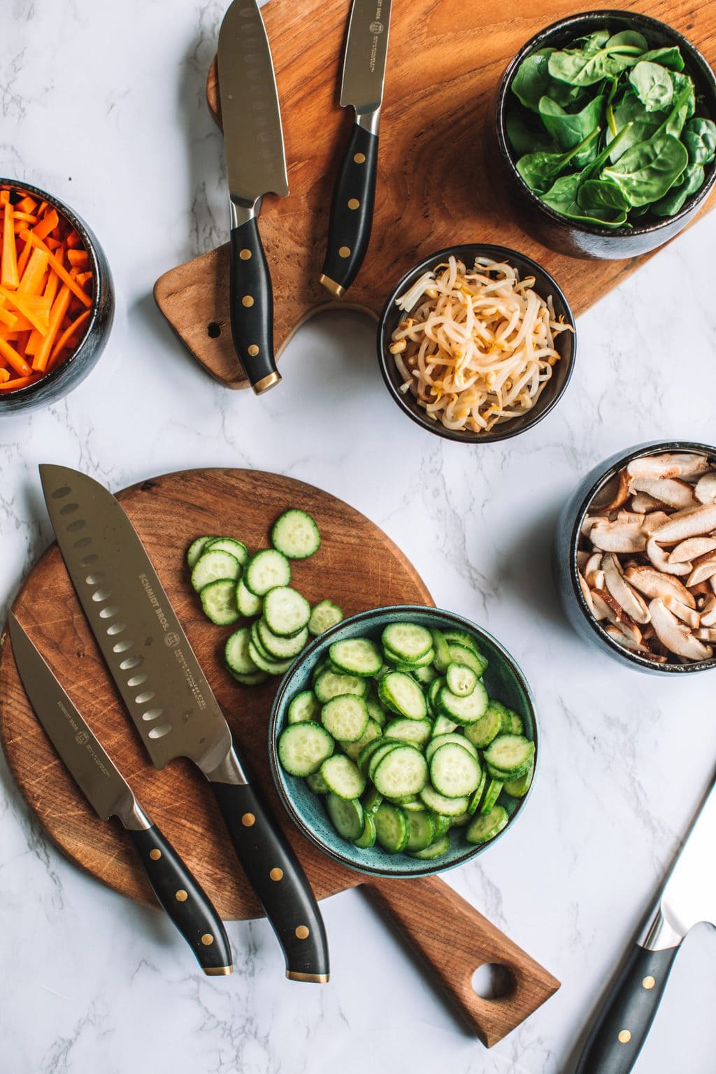 top shot of rice bowl ingredients next to kitchen knives on table