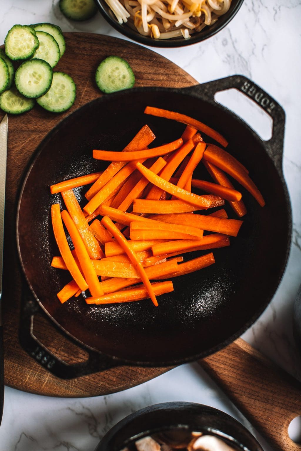 top shot of sliced carrots in black skillet