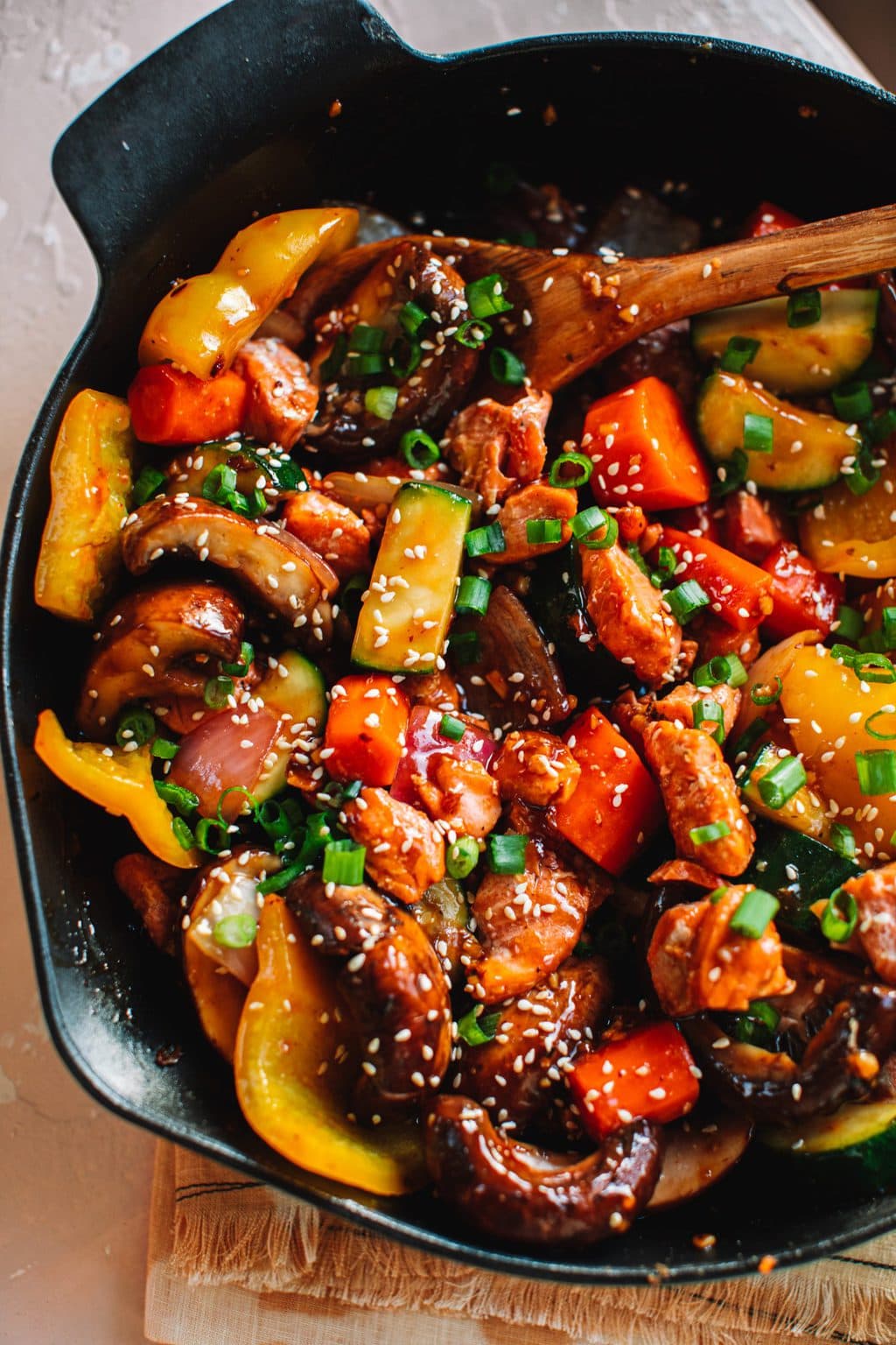 salmon stir fry with vegetables in cast iron skillet