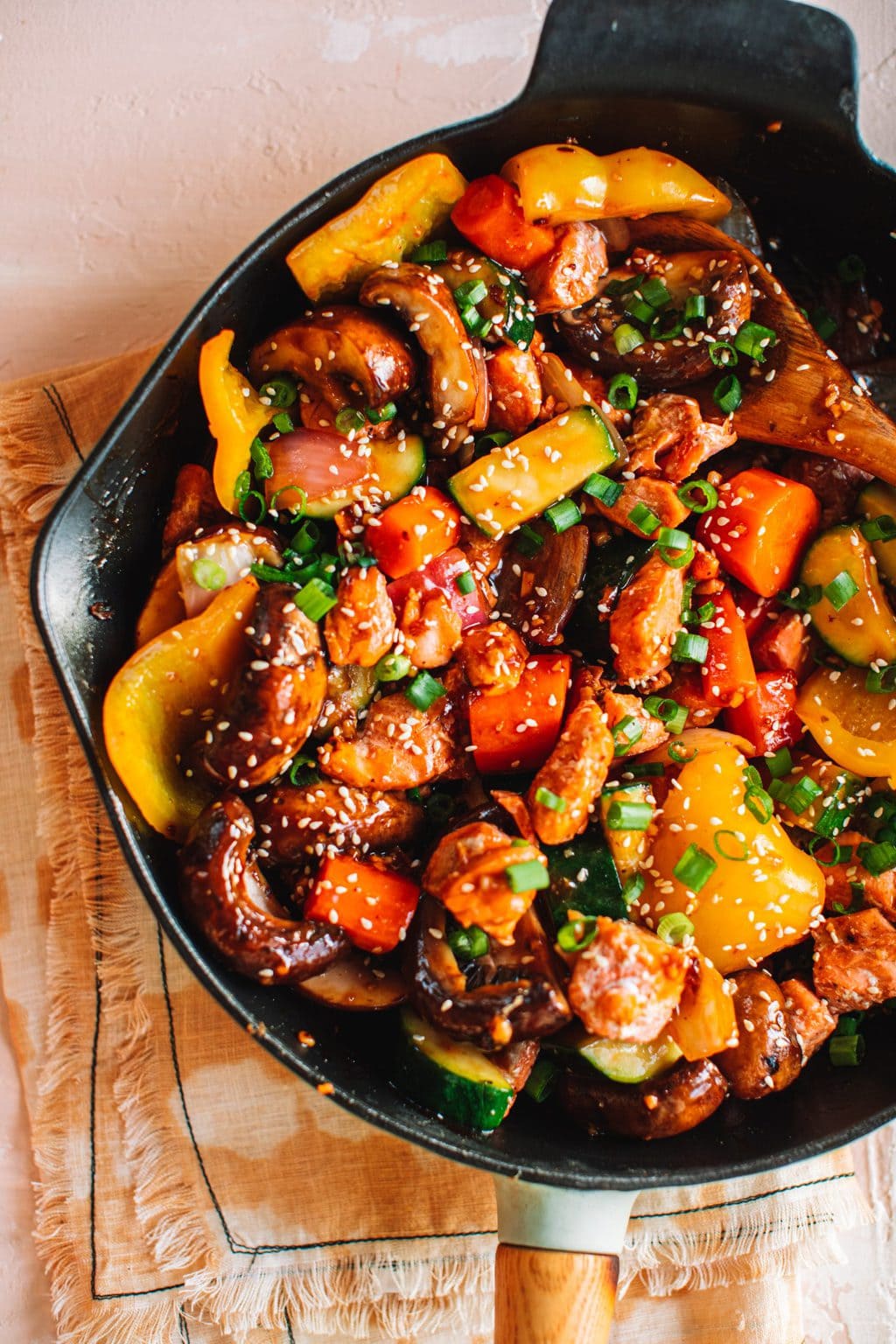 salmon stir fry with vegetables in cast iron skillet