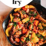 salmon stir fry with vegetables in cast iron skillet