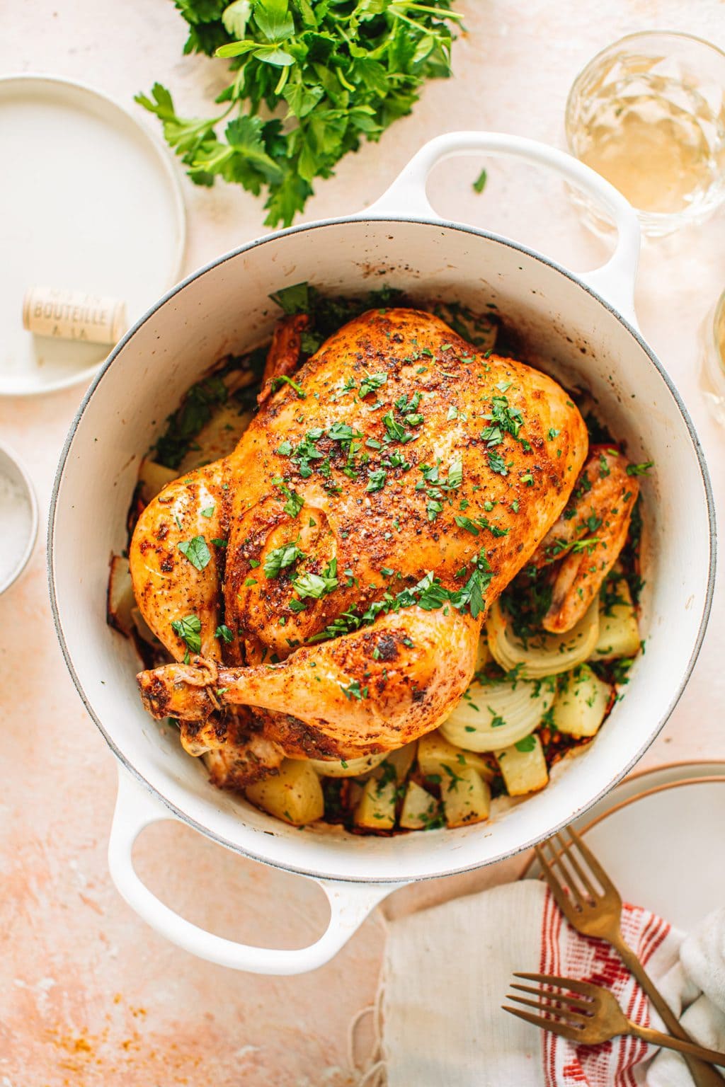 Top shot of cooked whole chicken garnished with parsley in large pot.