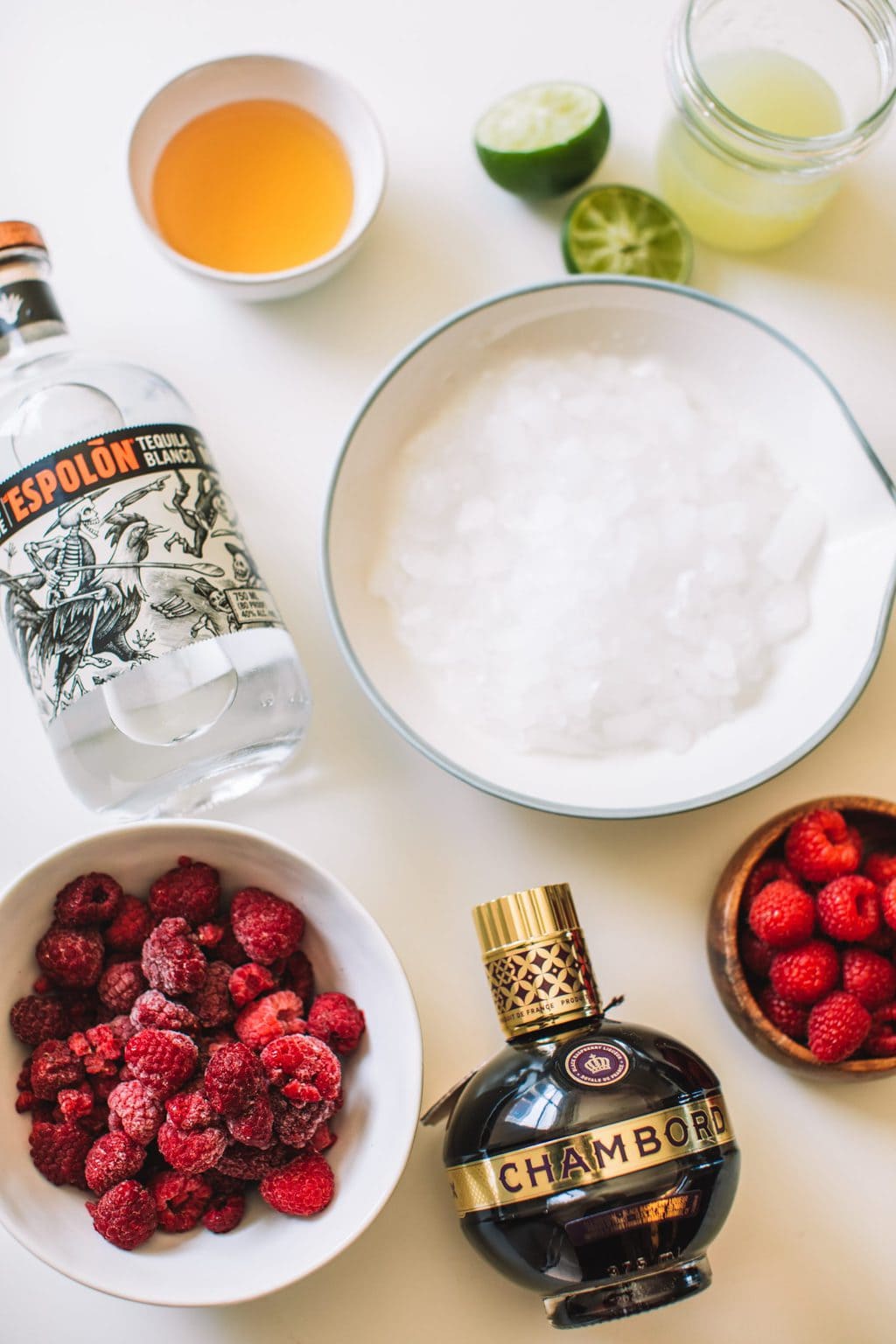 Silver tequila bottle, agave, frozen raspberries, ice, lime juice, chambord and fresh raspberries. 