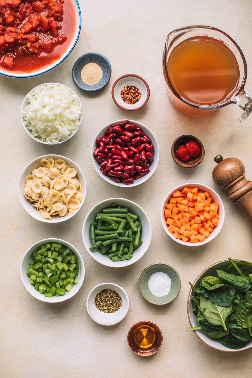 Minestrone Soup Olive Garden Style ingredients separated into small bowls on countertop.