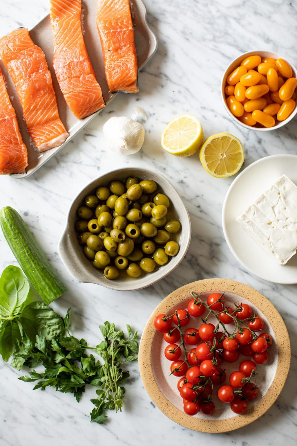 four salmon fillets, tomatoes, lemon, garlic, feta, olives, cucumber, parsley