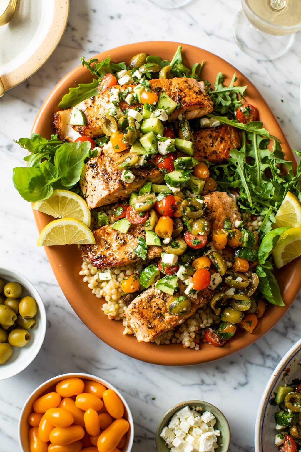 easy baked salmon recipe over couscous on large orange platter