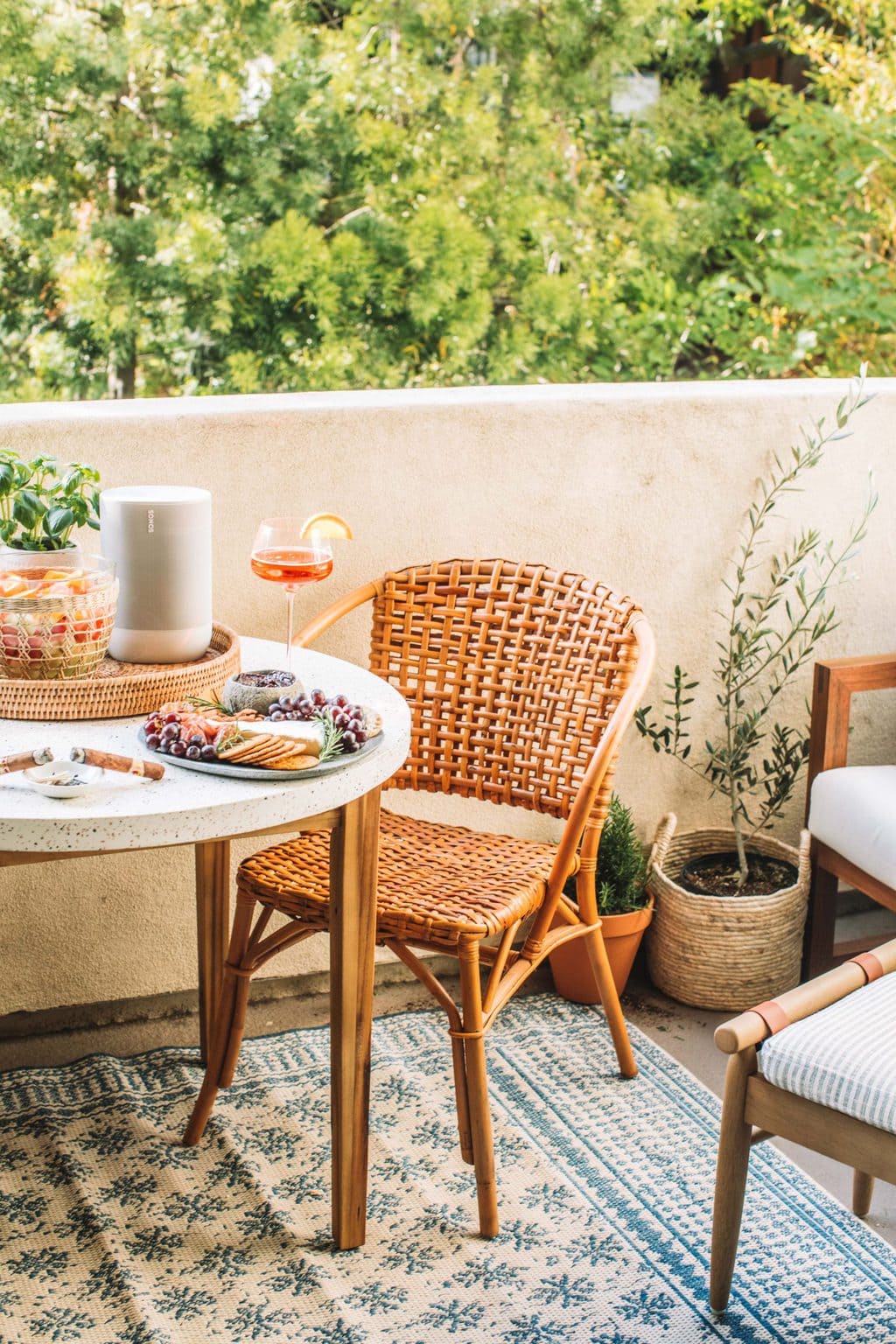 A round dining table with a cheese board and an aperol spritz on top. 