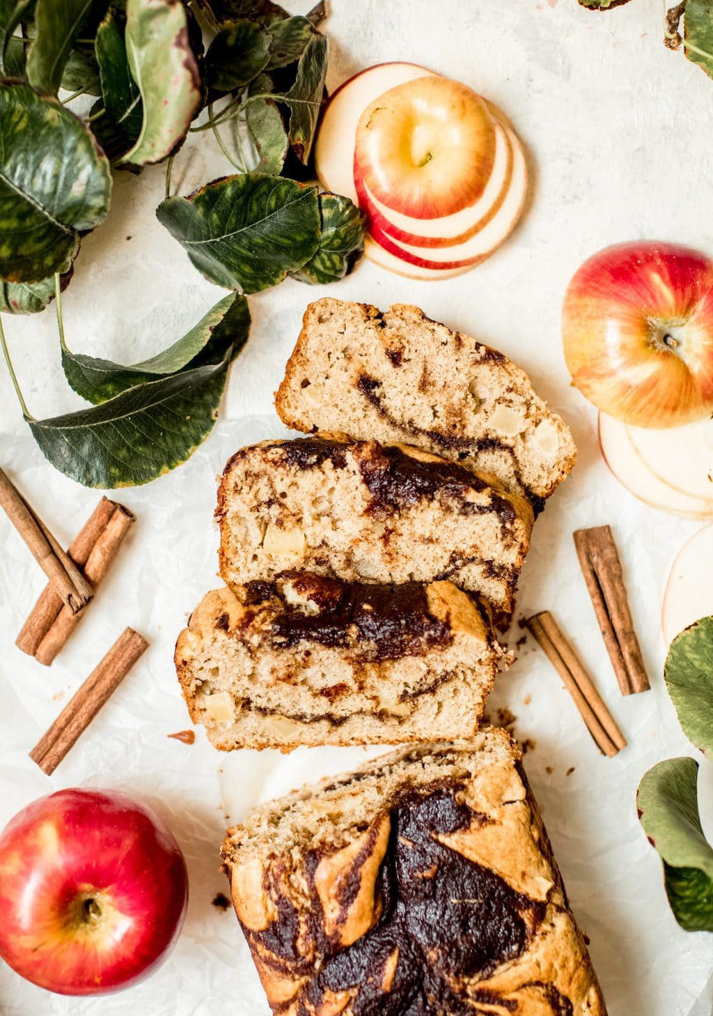 sliced apple loaf cake with cinnamon sticks and apples