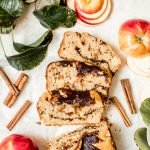sliced apple loaf cake with cinnamon sticks and apples