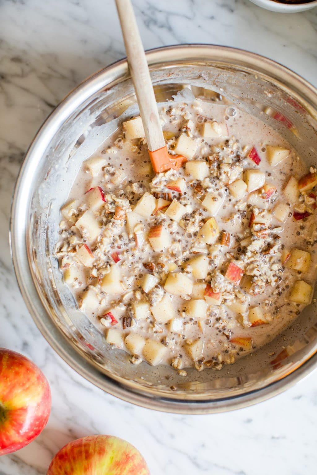 oats, diced apples, chia and milk in bowl with spatula