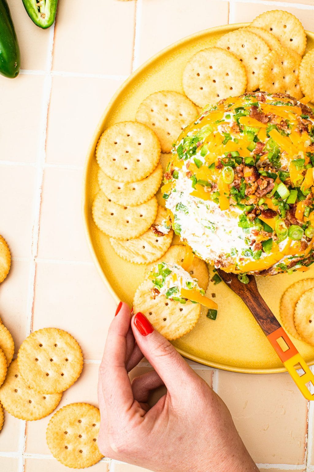 hand holding platter with cheese ball and crackers