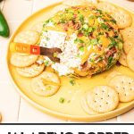 knife dipped in jalapeno cheese ball on platter with crackers