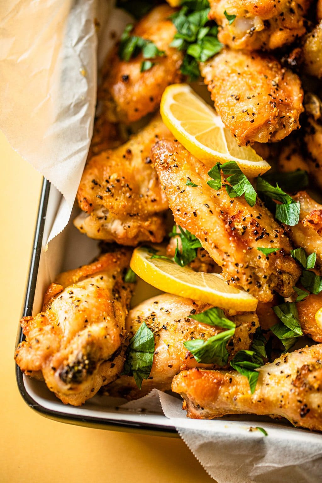 baked chicken wings with lemon wedges and parsley