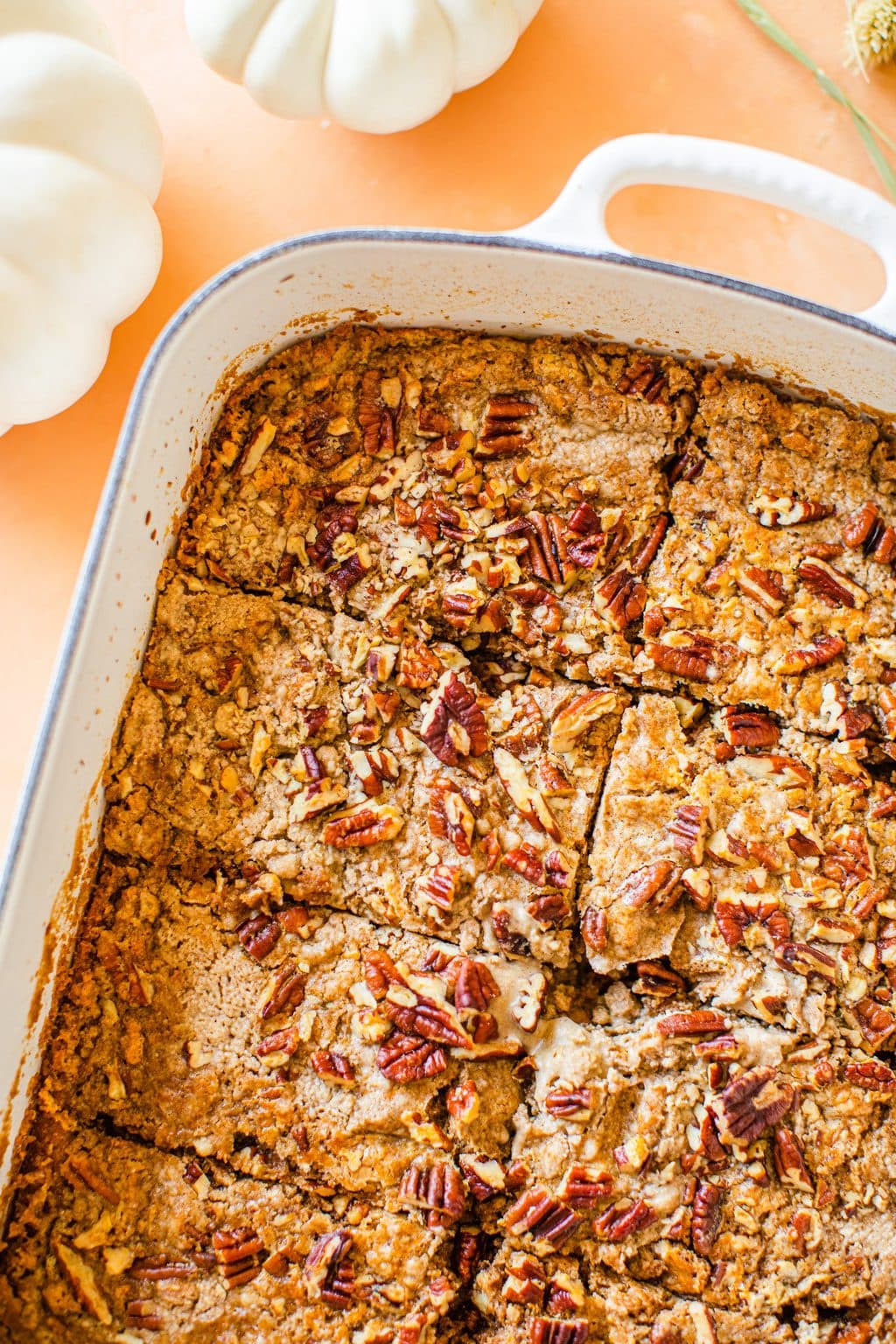 pumpkin dump cake in a white casserole dish cut into slices