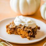 a slice of pumpkin dump cake topped with whip cream