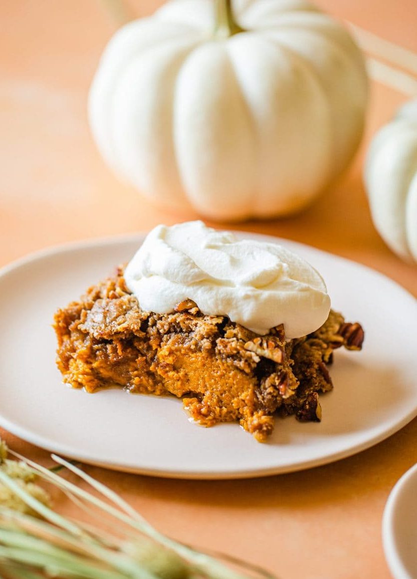 a slice of pumpkin dump cake topped with whip cream