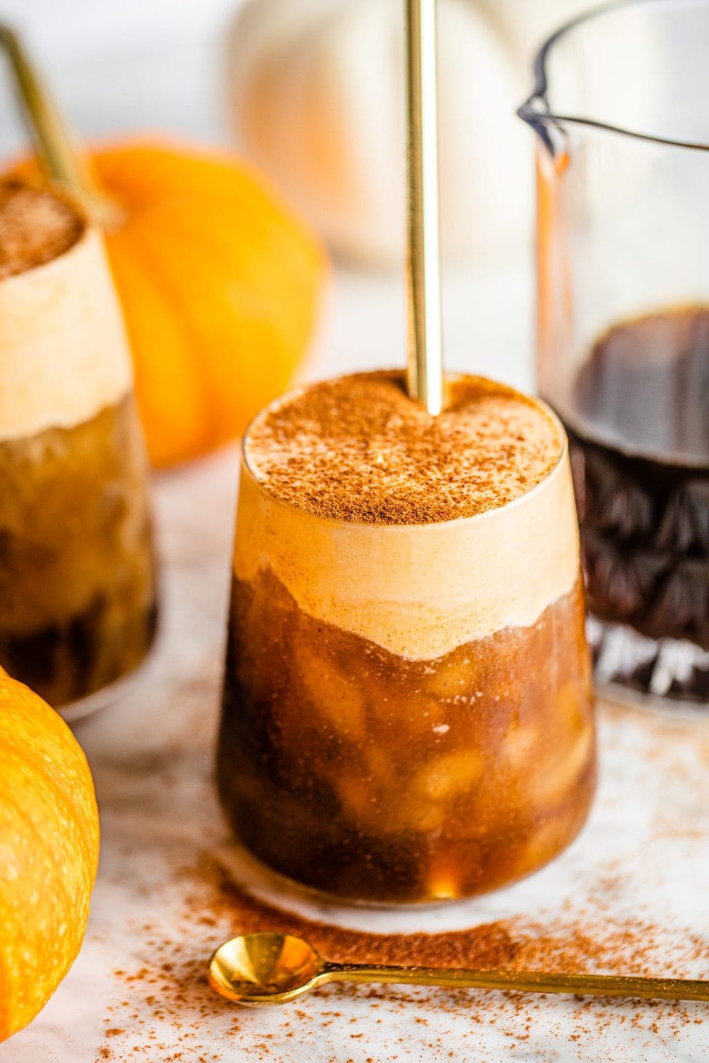 pumpkin foam coffee in glass with gold straw