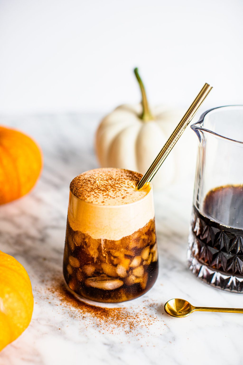 pumpkin cold brew in glass with gold straw