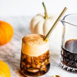 pumpkin cold brew in glass with gold straw