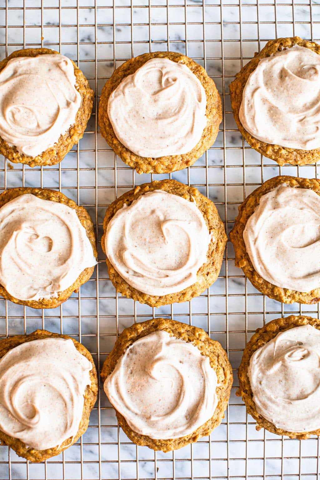 pumpkin spice cookies with frosting on cooling rack