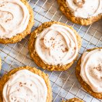 pumpkin oat cookies with icing on cooling rack