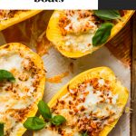 spaghetti squash filled with meat, sauce and cheese on baking sheet