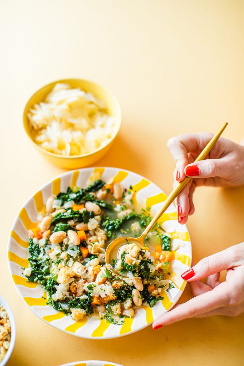 gold spoon dipped in bowl of white bean soup