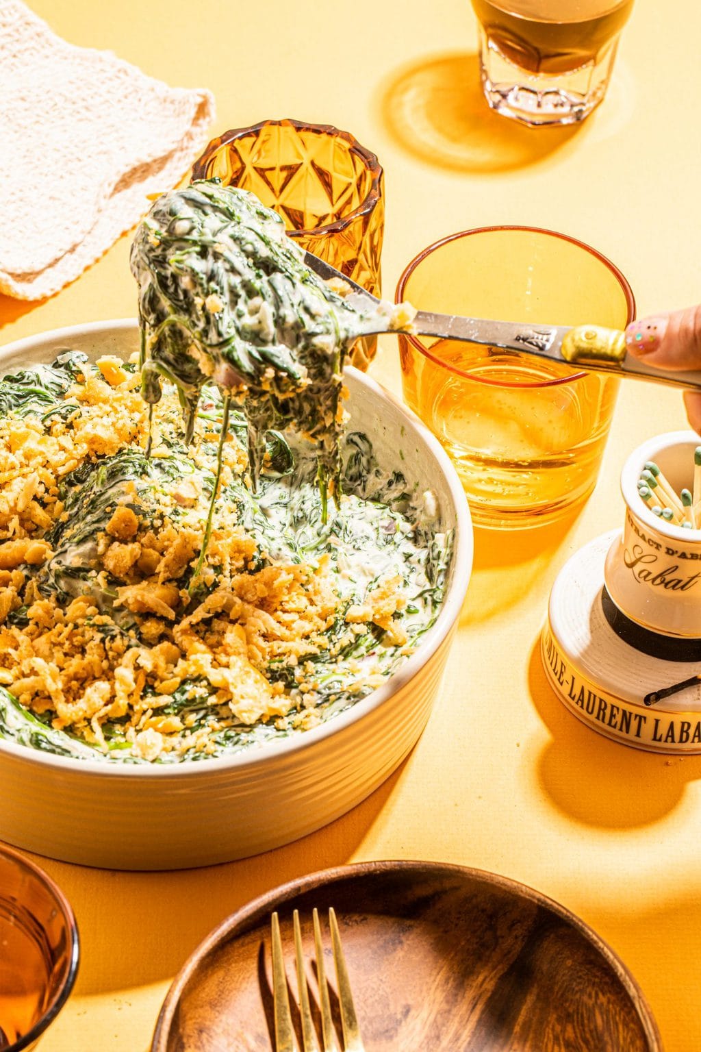 spoonful of creamed spinach with cracker topping