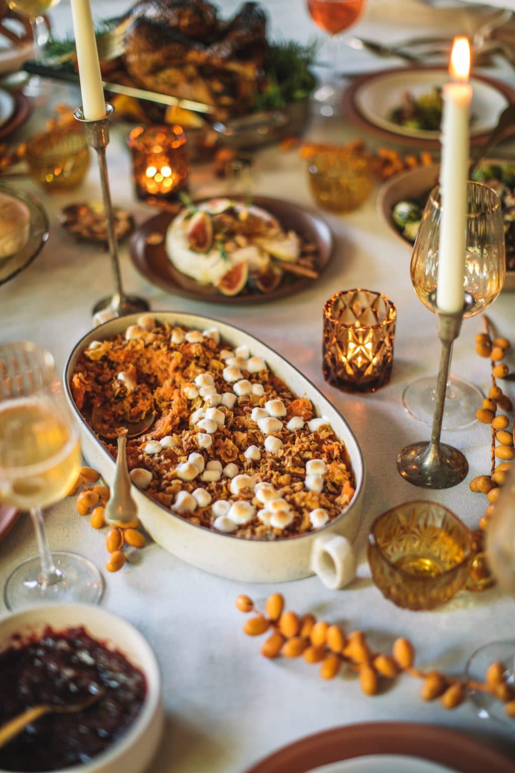 Mashed sweet potatoes on a Thanksgiving table with a golden spoon. 